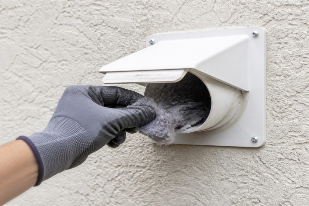 Exterior dryer vent being cleaned.
